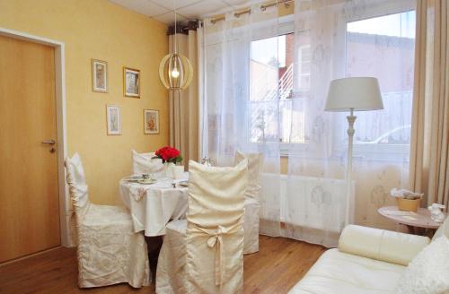 a dining room with a table and chairs and a window at City Apartment Papenburg in Papenburg