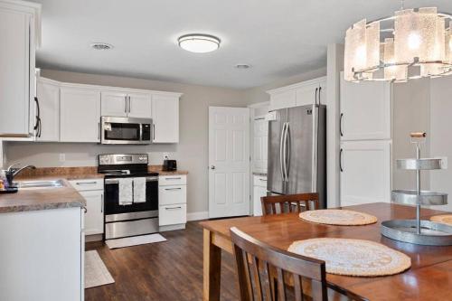a kitchen with white cabinets and a wooden table at The Archer Home in Springfield