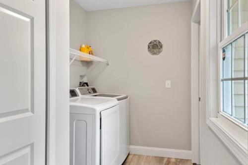 a white laundry room with a white washing machine at The Archer Home in Springfield