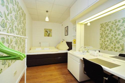a bathroom with a bed and a sink in a room at City Apartment Papenburg in Papenburg