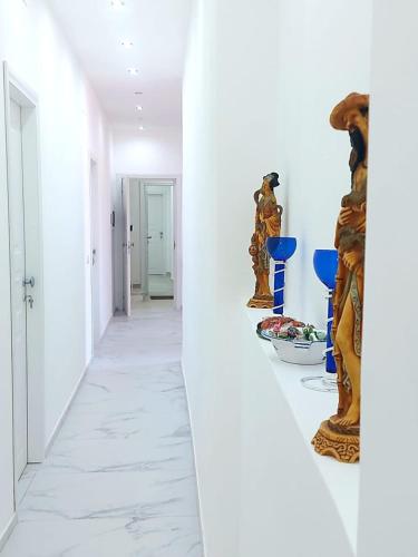 a hallway with white walls and a white floor with sculptures at Villa Anna al Duomo in Taormina