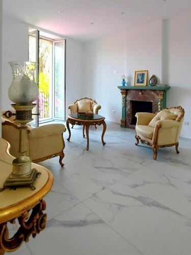 a living room with two chairs and a fireplace at Villa Anna al Duomo in Taormina