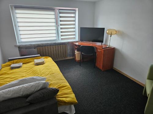 a bedroom with a bed and a desk with a computer at Apartament Ogrodowa in Biała Podlaska