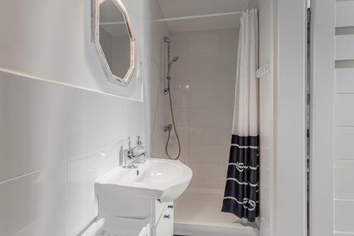 un bagno bianco con lavandino e specchio di Domek nad wodą a Kamień Pomorski