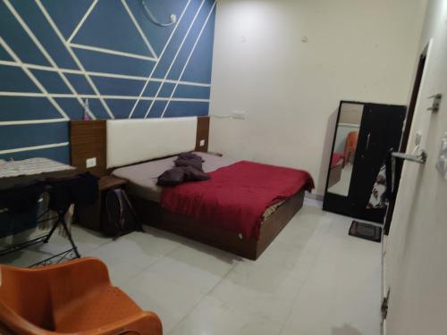 a bedroom with a bed and a chair and a mirror at The Himalayan Inn Hotel in Narendranagar