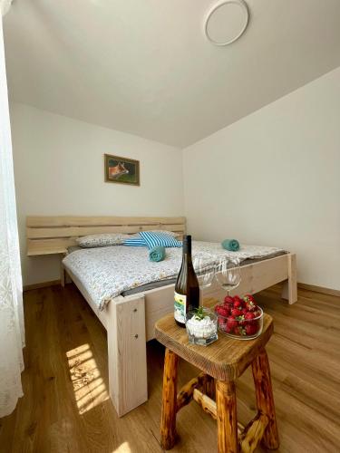 a bedroom with a bed and a table with a bottle of wine at The Wood Nest Apartment in Borovnica