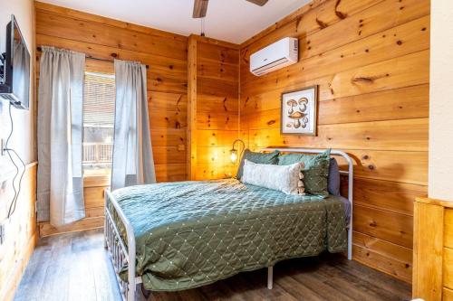 a bedroom with a bed in a room with wooden walls at Relaxing Getaway at Smoky Arcade & Resort Pool in Pigeon Forge
