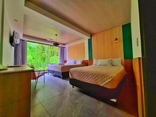 a hotel room with two beds and a window at Las Luciernagas Hotel in Flores