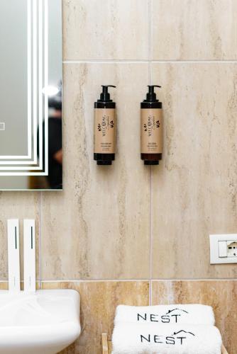 a bathroom with three soap dispensers on the wall at Poseidon Nest - 2BR, 360 Sea View, Office, Pool in Durrës