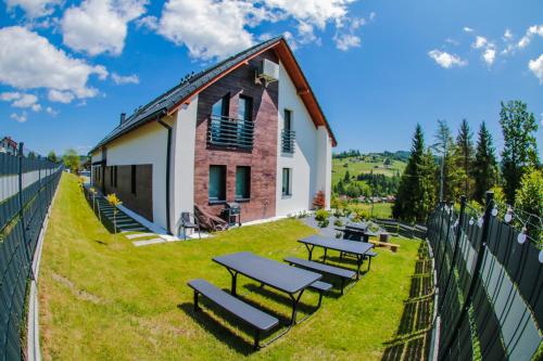 a group of picnic tables on the side of a building at Willa Jaworzynka 1103 K Istebnej in Jaworzynka