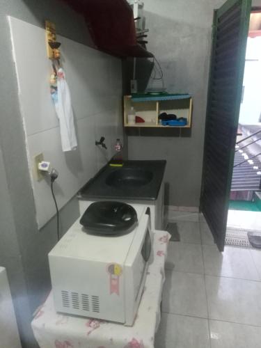 a small kitchen with a stove and a toilet at kitnet - Studio de Hóspedes da Menina Maricotinha in Manaus