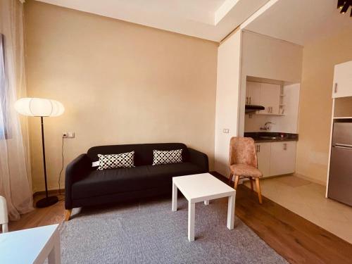 a living room with a black couch and a table at Relax Family 04 - Cozy Entire Apartment in City Center in Ouarzazate