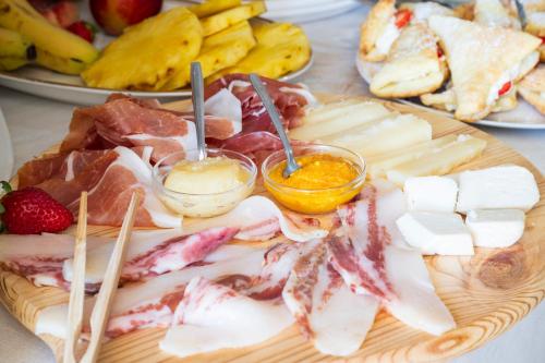 a plate of food with meats and cheese on a table at B&B Steddueoro in Baunei