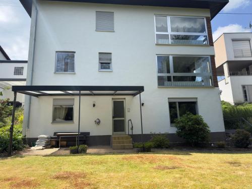 a white house with a black awning at 70qm Apartment mit Stellplatz und Garten in Riegelsberg
