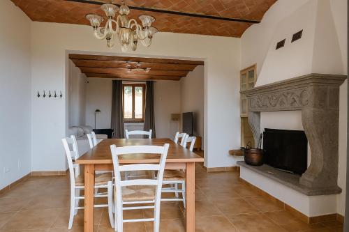 a dining room with a table and chairs and a fireplace at Villa La Gioconda in Arezzo