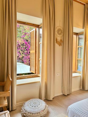 a bedroom with a large window and a table at Old Town Suites Muradie in Vlorë