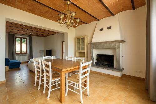 a dining room with a table and chairs and a fireplace at Villa La Gioconda in Arezzo