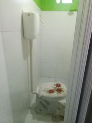 a small bathroom with a toilet in the corner at kitnet - Studio de Hóspedes da Menina Maricotinha in Manaus