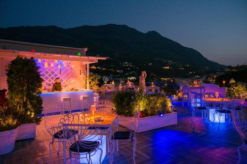 a patio with tables and chairs at night at Hotel Casa Di Meglio in Ischia