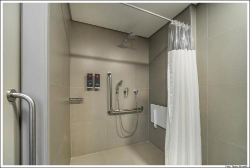 a shower with a shower curtain in a bathroom at Mercure Sao Paulo Barra Funda in Sao Paulo