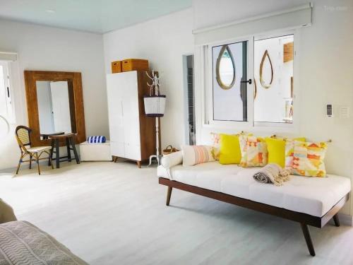 a living room with a white couch with colorful pillows at Hotel Luna Bella in Talamanca