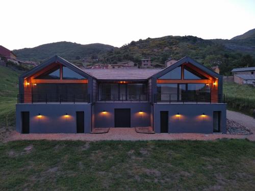 a house on a hill with the lights on at La Finca del Valle in Valle de Vegacervera