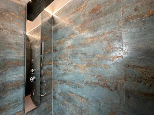 a shower in a bathroom with a stone wall at Villa La Gioconda in Arezzo