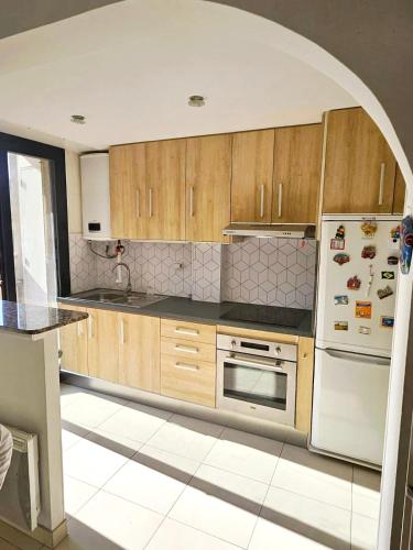 une cuisine avec des armoires en bois et un réfrigérateur blanc dans l'établissement Beautiful bright apartment, à Cannes