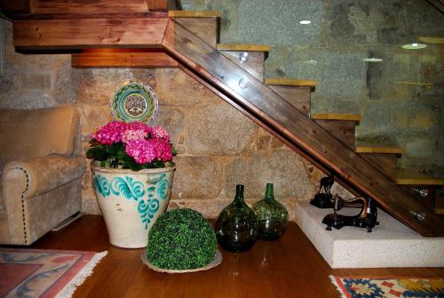 una sala de estar con una escalera y un jarrón con flores en Hotel Real Cambados, en Cambados