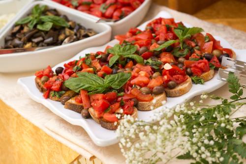a table topped with plates of food with sandwiches at Hotel Casa Di Meglio in Ischia