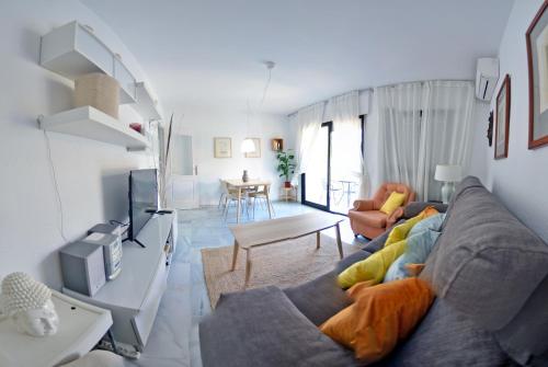 a living room with a couch and a tv at Paraíso del Sol in Salobreña