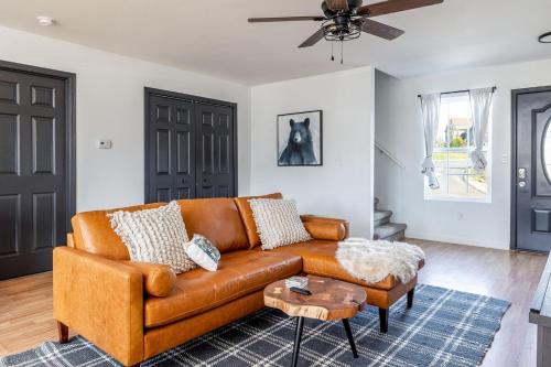 ピジョン・フォージにあるCozy Cabin Retreat w Arcade Hot Tub near Dollyのリビングルーム(茶色の革張りのソファ、テーブル付)