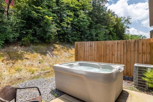 a bath tub sitting in a yard next to a fence at Comfortable Escape near Dolly w Hot Tub in Sevierville