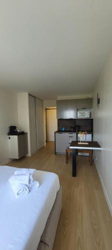 une chambre avec un lit et une cuisine avec une table dans l'établissement Charming Studio near La Defense, à Courbevoie
