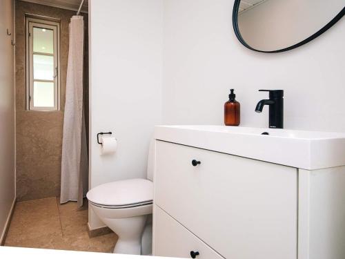 a white bathroom with a toilet and a mirror at 6 person holiday home in Haderslev in Haderslev