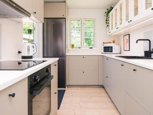 a white kitchen with a sink and a microwave at 6 person holiday home in Haderslev in Haderslev