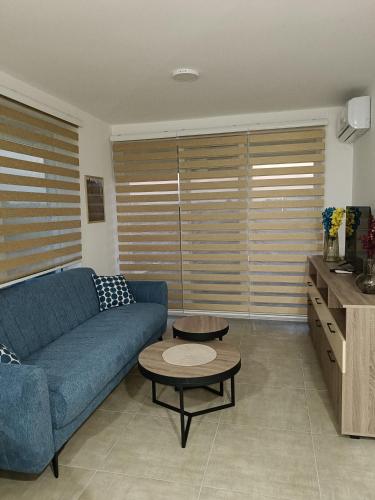 a living room with a blue couch and a table at Apartman Sara S in Veliko Gradište