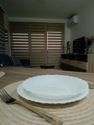 a white plate and a fork on a table at Apartman Sara S in Veliko Gradište