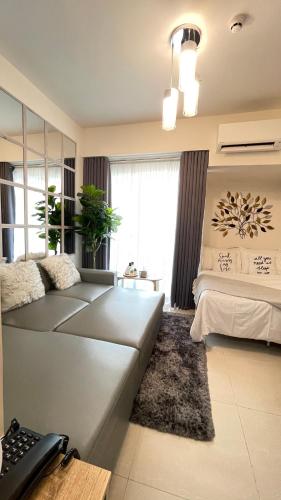 a living room with a couch and a bed at Davao Inspiria Condominium units with balcony beside Abreeza Mall in Davao City