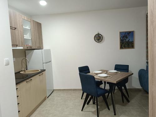 a small kitchen with a table and chairs in a kitchen at Apartman Sara S in Veliko Gradište
