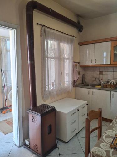 a kitchen with a stove in the corner of a room at Kaloxori Apartment - Limnothalassa in Thessaloniki