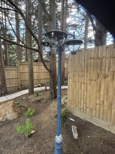 a blue street light in a yard next to a fence at Tawny Lodge, Evesham Nr Cotswolds in Evesham