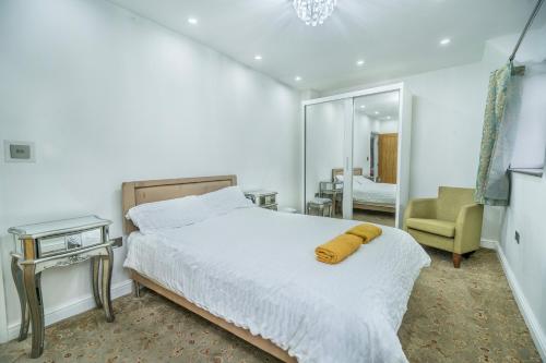 a bedroom with a bed with a yellow blanket on it at Farm House Manor Luxury 8 bedrooms & 7 bathrooms Farm House & 40 mins away from Tower in Little Bridgeford