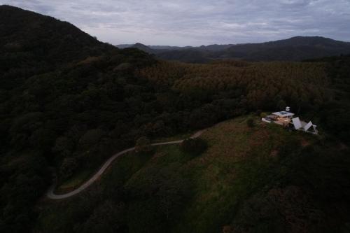 a house on a hill in the middle of a forest at Blue Sky Lodge in Nicoya