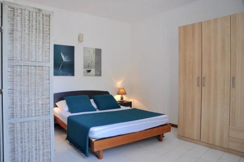 a bedroom with a bed with blue pillows at Domaine Bocca di Feno in Bonifacio