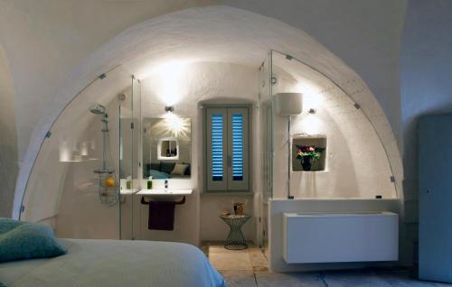 a bedroom with a bed and a sink and a tub at Palazzina Alchimia in Fasano