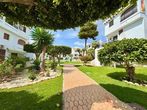 a walkway in a park next to a building at Oleza garden in Playa Flamenca