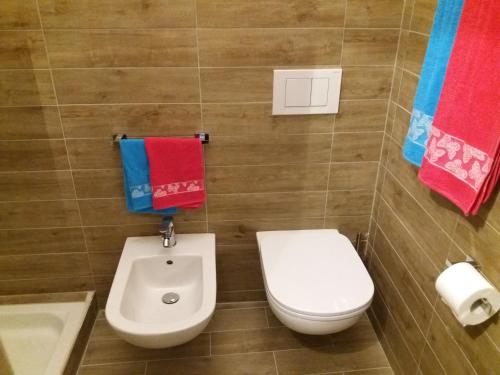a bathroom with a toilet and a sink and towels at Scalovecchio in Marettimo