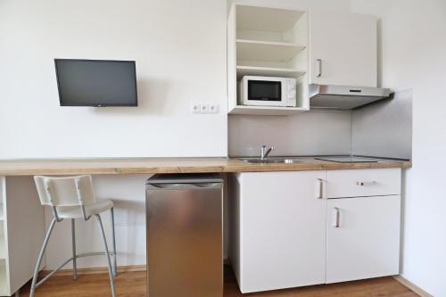 a kitchen with a counter with a sink and a microwave at Penzion Vintrovna in Popůvky