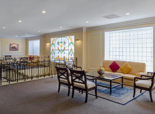 a waiting room with a couch and chairs and a stained glass window at Hotel Francia Aguascalientes in Aguascalientes